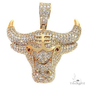 Yellow gold bull pendant encrusted with diamonds and red gemstone eyes.