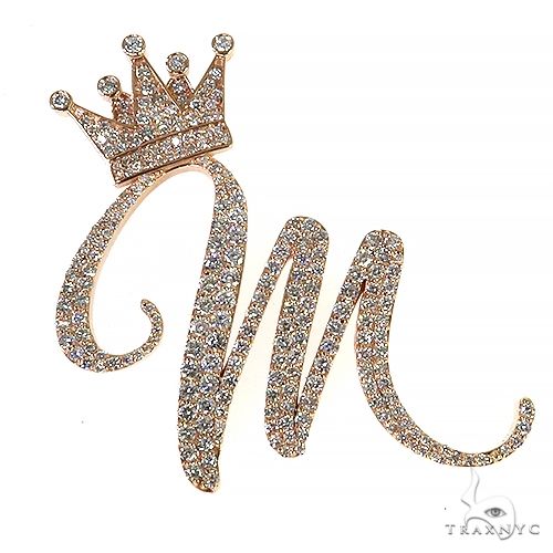 Rose gold diamond initial pendant featuring a cursive "m" with a crown accent