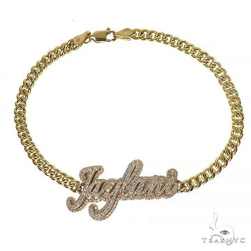 Gold chain bracelet with custom diamond-encrusted script name pendant.