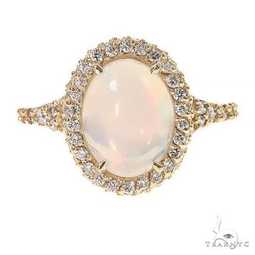 Yellow gold ring with oval opal center stone and surrounding small diamonds.