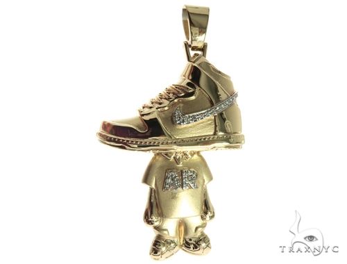 Yellow gold sneaker pendant with diamond accents and a dangling figure charm