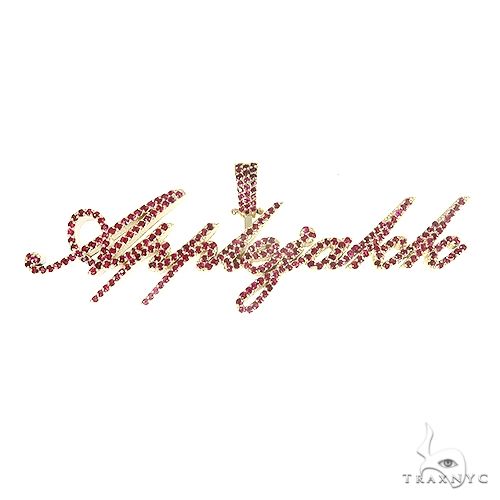 Custom script 'AppleJakk' ruby pendant in 14k yellow gold – diamond-accented flowing letterform, front view