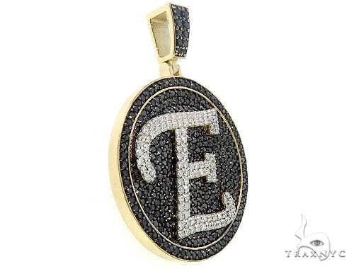 Round gold pendant with black and white diamonds forming the letter E on black background