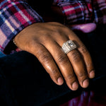 Yellow gold men's ring with large center diamond and multiple surrounding diamonds.