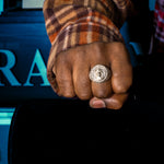 Gold circular men's ring with Jesus head and diamond accents in concentric circles.