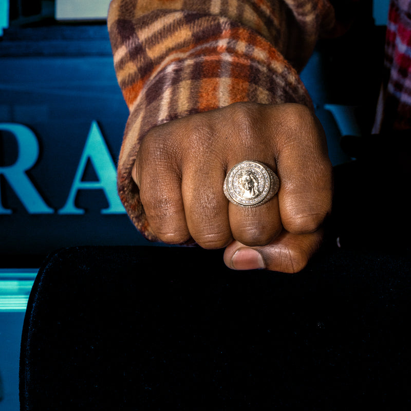 Gold circular men's ring with Jesus head and diamond accents in concentric circles.