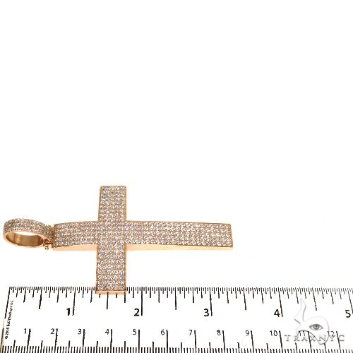 Men’s rose gold cross pendant encrusted with small diamonds, shown with a ruler for size