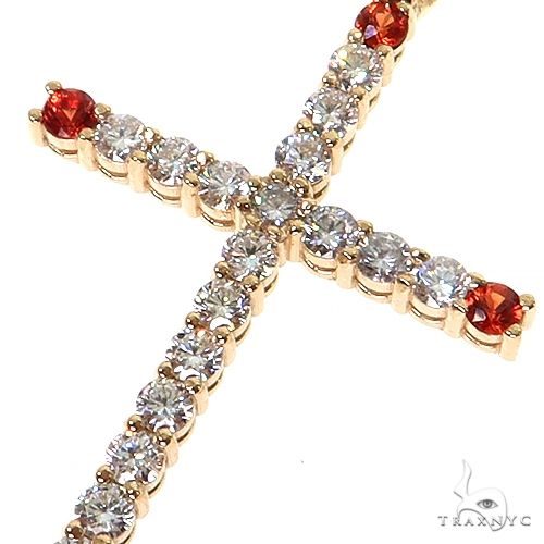 Gold cross pendant with round diamonds and red gemstone accents at ends
