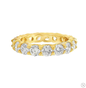 Yellow gold eternity band with round diamonds encircling the ring in a shared prong setting.