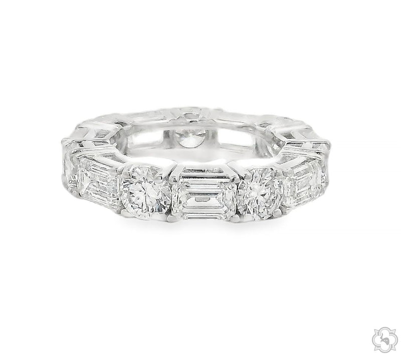 Diamond eternity ring with alternating emerald and round cut stones set full circle – top-down view