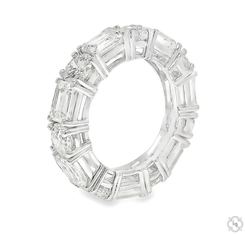 White gold diamond eternity ring with mixed round and emerald cut stones