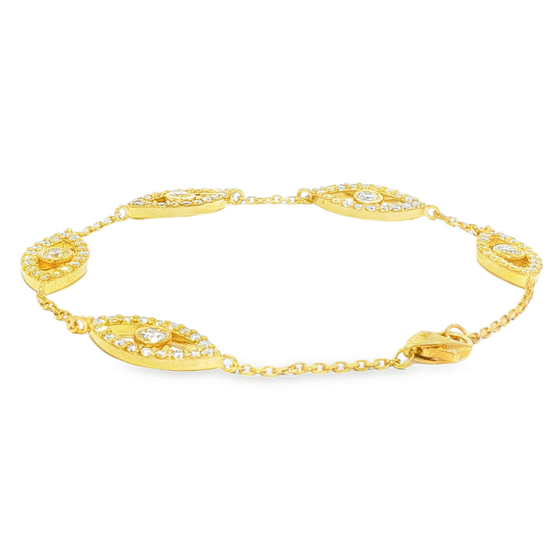 Gold bracelet with evil eye motifs adorned with yellow diamonds and clear stones.