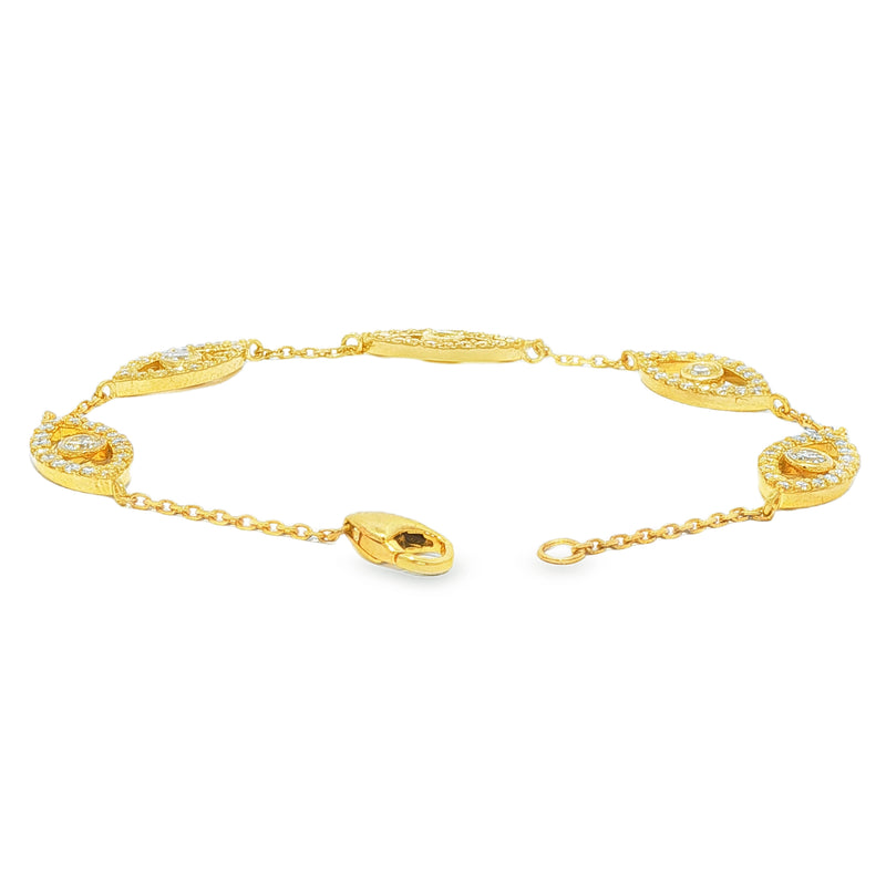 Gold bracelet with evil eye motifs adorned with yellow diamonds and clear stones.