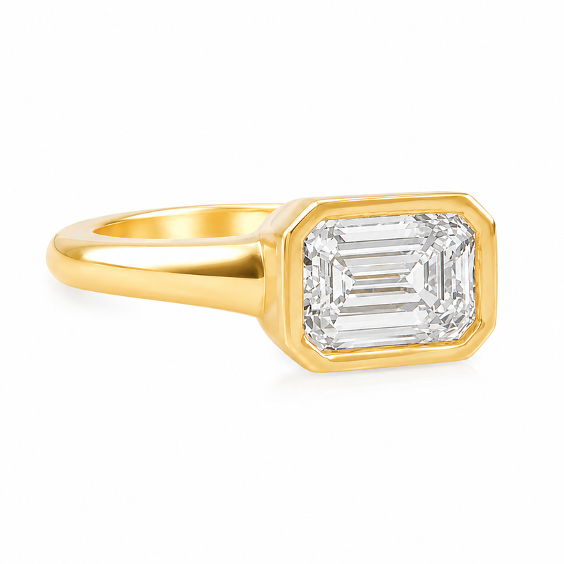 Yellow gold ring with emerald-cut diamond bezel setting, sleek polished band