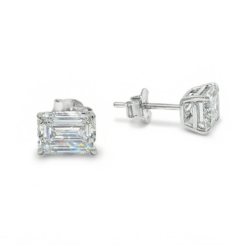 Pair of emerald cut diamond stud earrings with four-prong white gold setting