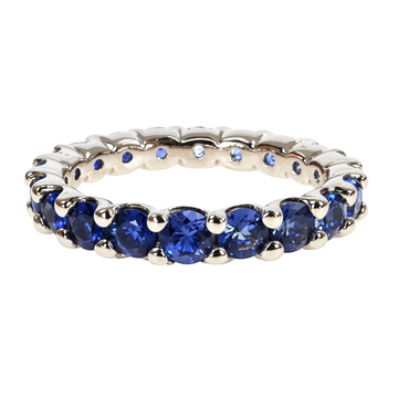 White gold eternity ring with graduated round blue sapphires in prong settings.