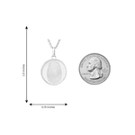Silver oval pendant with fingerprint engraving and matching silver chain next to a quarter for size.