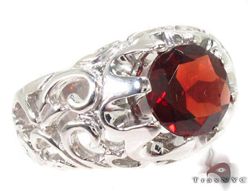 Men's sterling silver ring with detailed patterns and a round garnet center