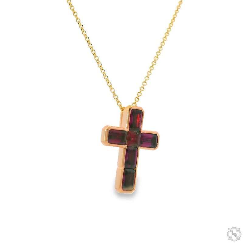 Gold cross pendant with deep red garnet gemstones on a delicate chain