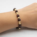 Adjustable natural red garnet bead bracelet with textured 14K gold beads and a black sliding cord.