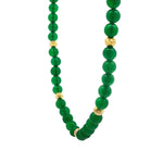 Necklace with round green gemstones interspersed with textured gold beads.