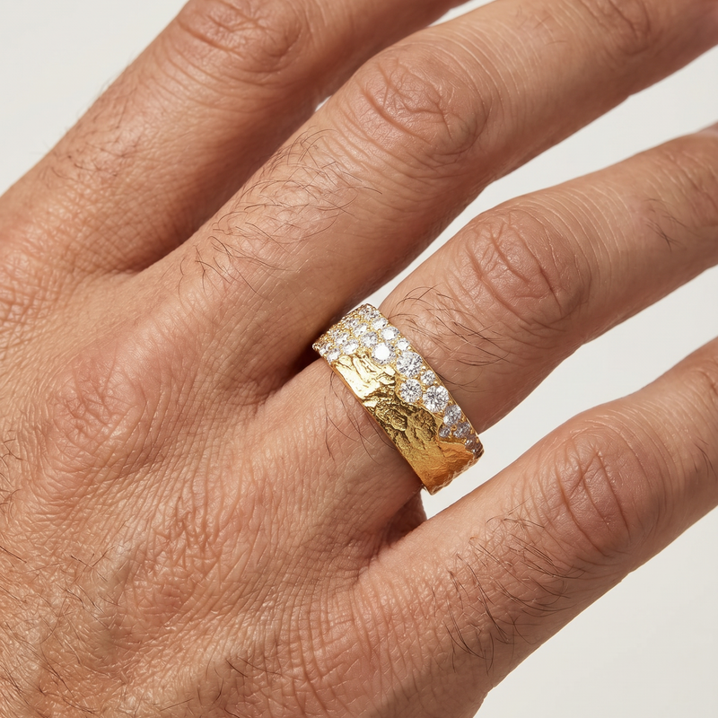 Wide gold wedding band with hammered texture and a row of small diamonds across the center.