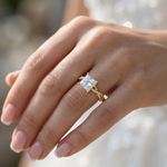 Yellow gold engagement ring with a princess cut diamond center stone on hand.