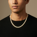 Yellow gold chain necklace with luminous opal gemstones worn on neck.