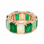 Rose gold eternity band with alternating rectangular emerald and opal gemstones.