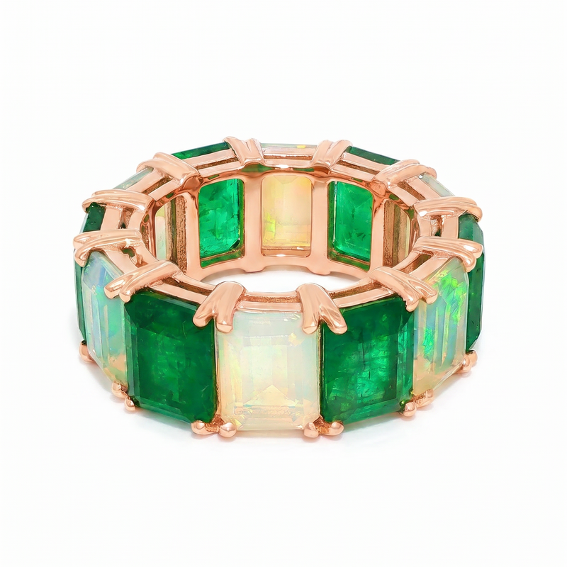 Rose gold eternity band with alternating rectangular emerald and opal gemstones.