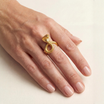 24k gold ring shaped like a coiled cobra with detailed scales and head on finger.