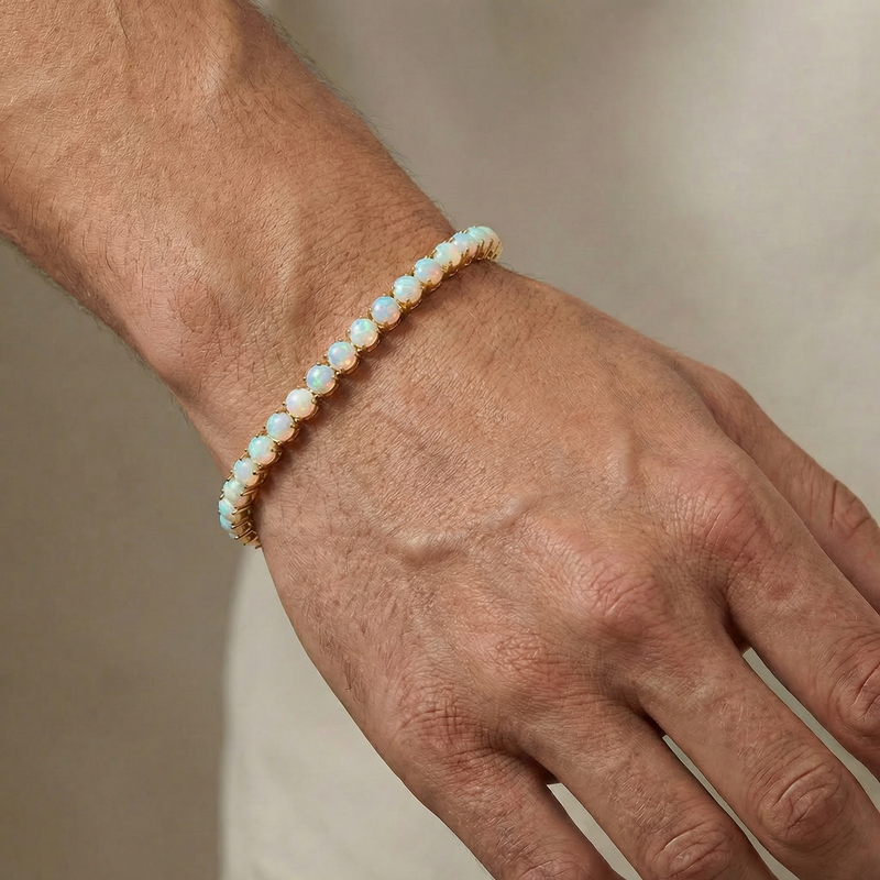 Gold tennis bracelet with oval opal gemstones, polished finish, unisex design.