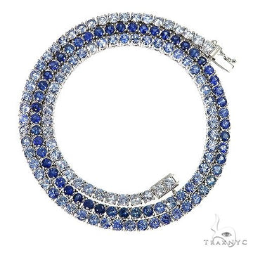 Graduated sapphire tennis chain necklace in white metal with deep blue gemstones.