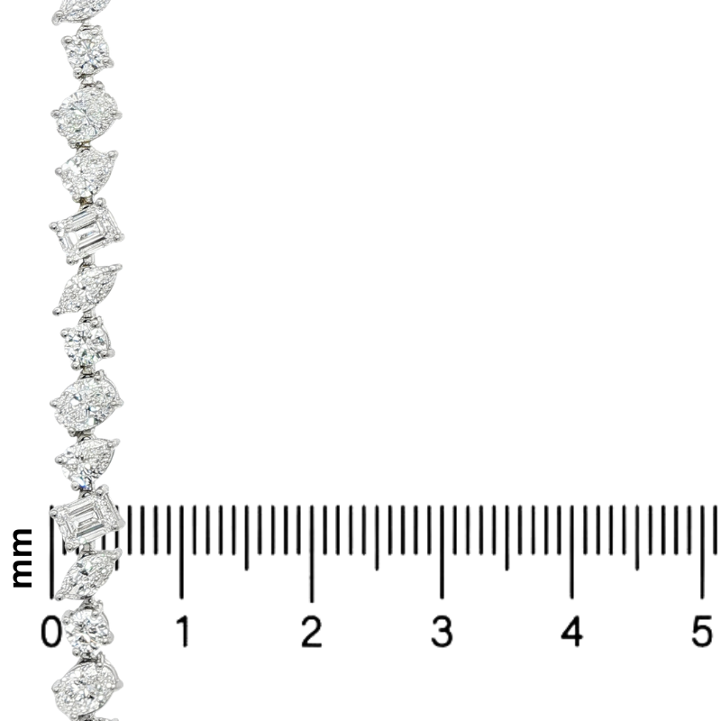 Silver bracelet with assorted diamond shapes, displayed alongside a millimeter ruler for size.