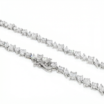 Silver diamond chain necklace with square-cut stones and secure clasp detailing.
