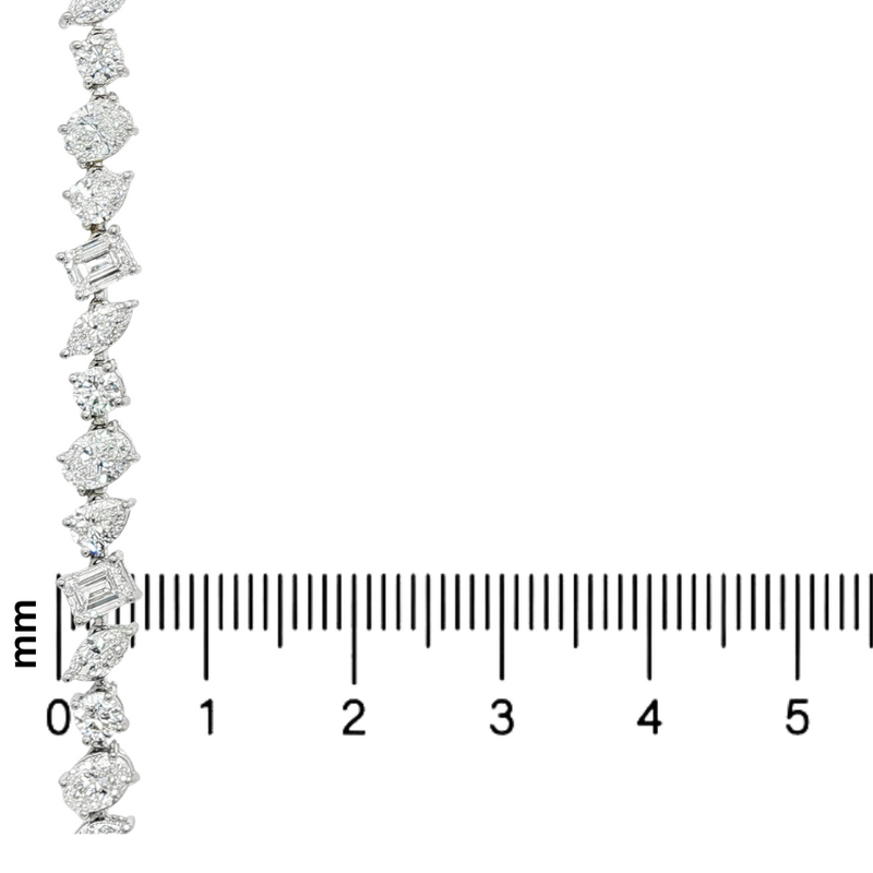 Silver chain necklace with alternating round and baguette diamonds above a millimeter ruler.