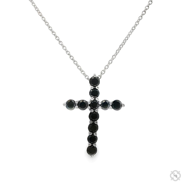 White gold cross pendant set with round black diamonds on delicate chain.