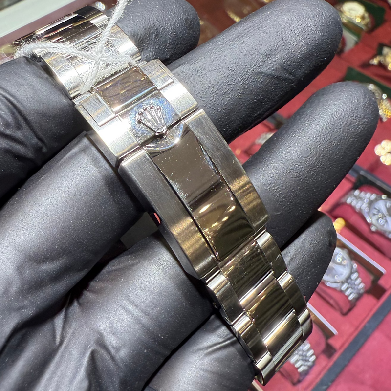 Blue and black two-tone bezel with engraved 24-hour numerals and a blue GMT hand indicating a second time zone.

