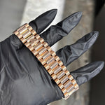 18K Everose gold Rolex Day-Date 40mm watch bracelet with polished center links held in gloved hand.