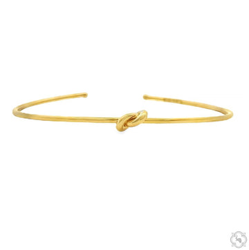 Gold knot bangle bracelet – continuous knot silhouette, smooth finish, side angle view