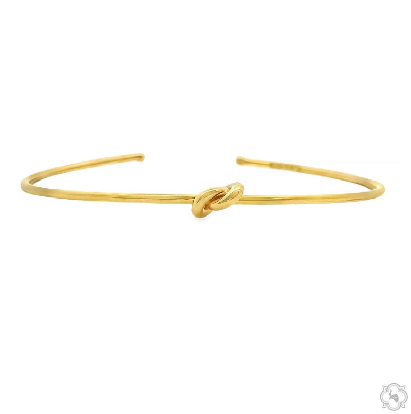 Gold knot bangle bracelet – continuous knot silhouette, smooth finish, side angle view