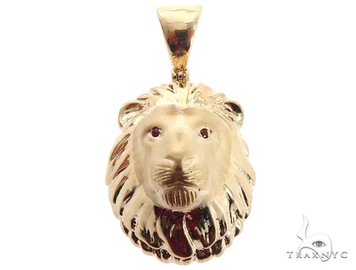 Yellow gold lion head pendant with detailed mane and ruby red eyes