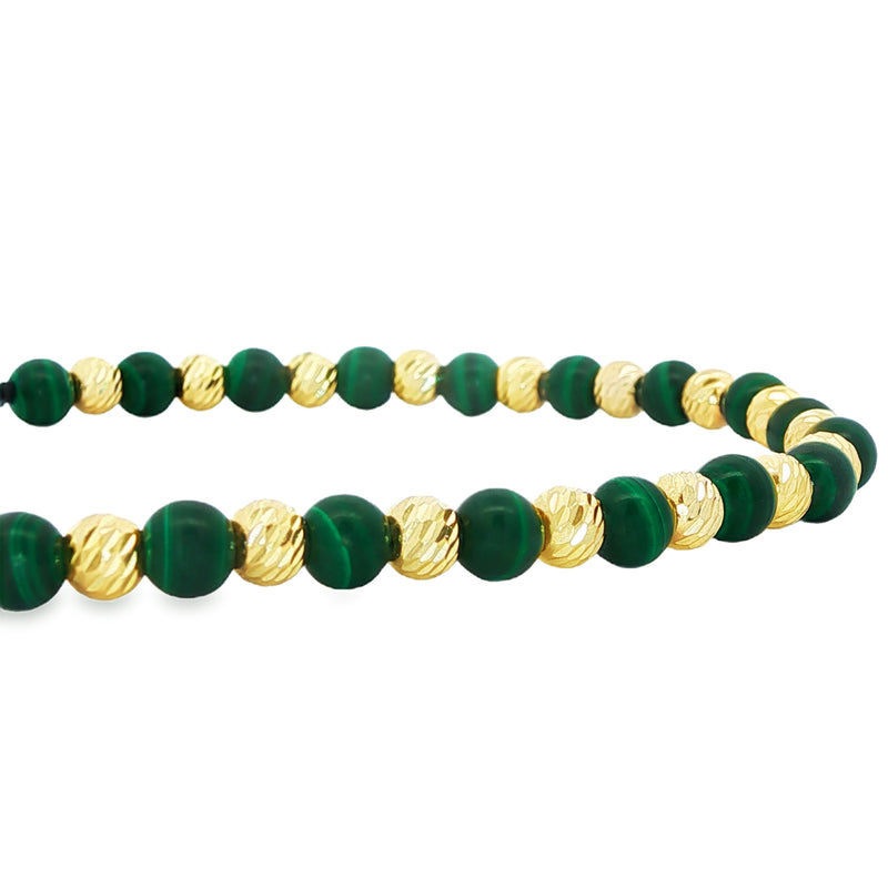 Adjustable bracelet with alternating green malachite and textured gold round beads on black cord.