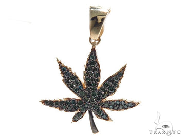 Yellow gold pendant shaped like a maple leaf with black diamond accents.