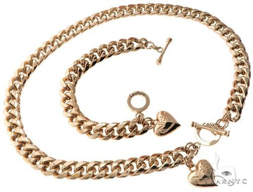 Miami Cuban chain and bracelet set in gold with custom locks and heart charm pendants, flat lay view