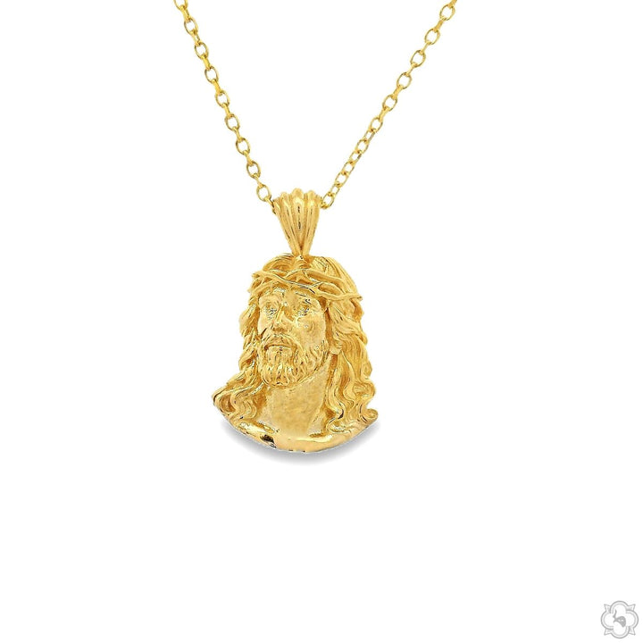 Yellow gold Jesus pendant with detailed facial features on a delicate chain.
