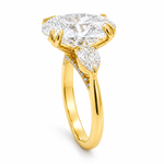 Oval three stone engagement ring with oval lab grown diamond, double claw prongs, tulip basket, and pear side diamonds