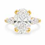Oval three stone engagement ring with oval lab grown diamond, double claw prongs, tulip basket, and pear side diamonds