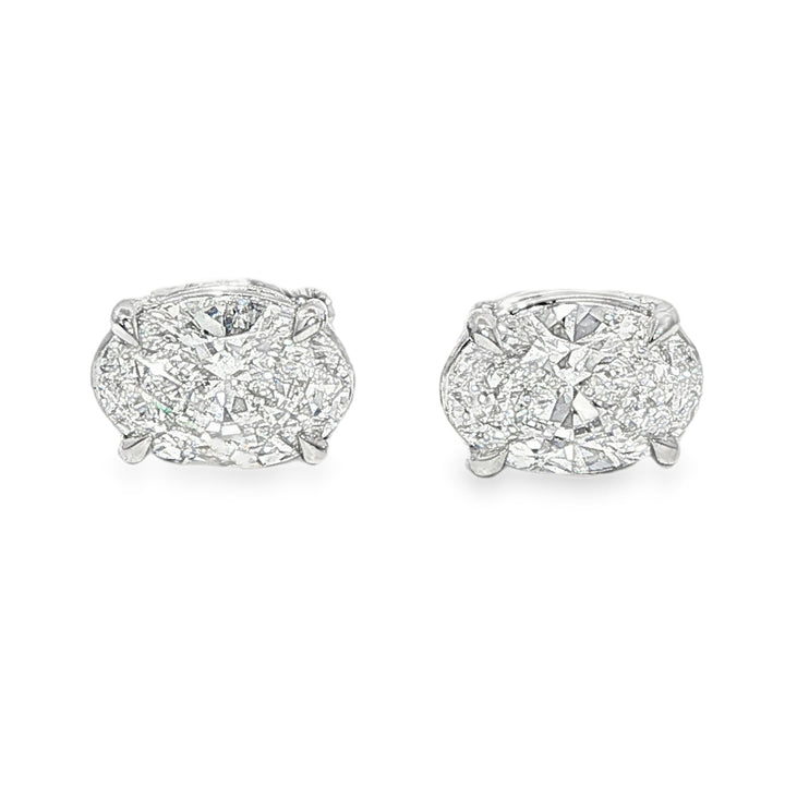 Pair of oval diamond stud earrings with cluster setting in white gold prong mount


