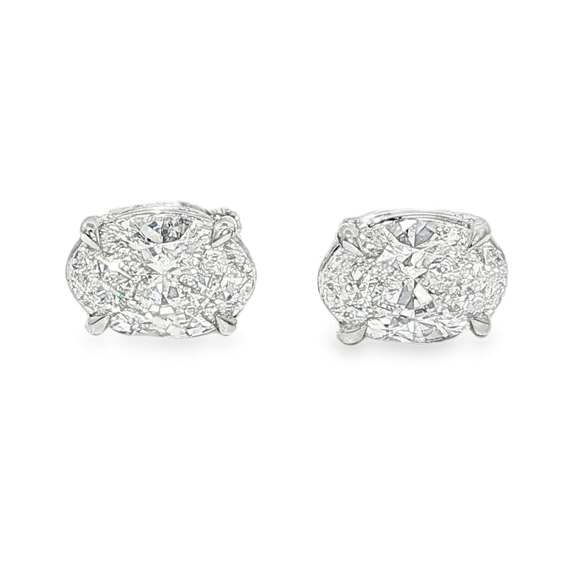 Pair of oval diamond stud earrings with cluster setting in white gold prong mount

